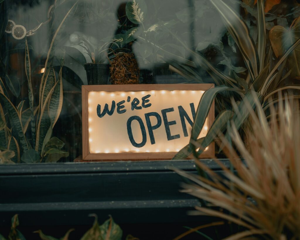 We're open sign in the window of a small business