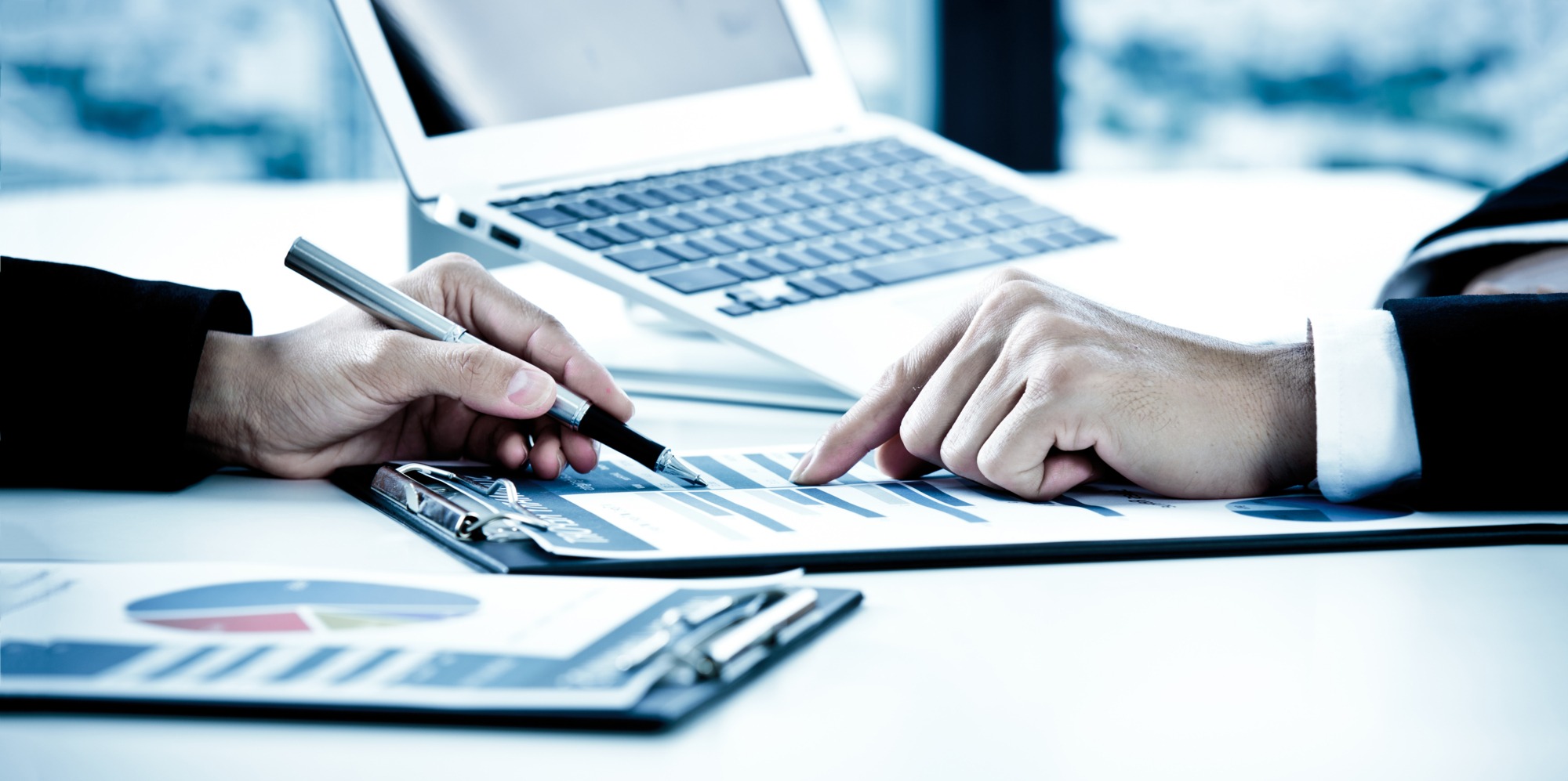 Business people discussing the charts and graphs showing the results of their successful teamwork.